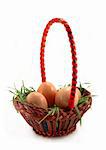Basket with grass and four Easter eggs