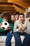 domestic life: group of friends watching a football match on tv