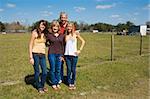 Grandparents and their beautiful granddaughters on the farm with room for text.