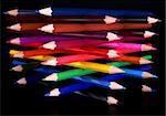 Top view of colorful pencils tower isolated over black background