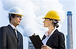 Young male and female managers working together in an industrial situation with