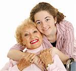 Portrait of loving grandmother and affectionate teen granddaughter.  White background.