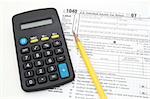 calculator an pencil over 1040 tax form