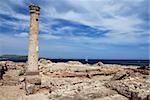Ancient Sardinian ruins of Nora with sea, ship and lighthouse
