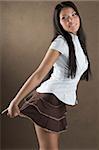 young and nice girl with white shirt and pulling a brown short skirt