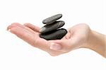 Female hand hold a stack of three dark stones. Isolated on a white background.