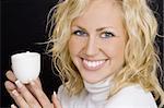 Studio profile shot of a beautiful young blonde woman drinking coffee