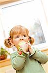 Little girl eating a green apple