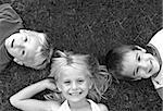 Three Friends Laying Grass in Black and White