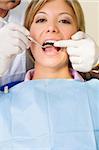 dentist using an angled mirror. Copy space. The focus is on woman's teeth