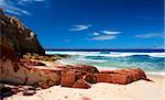 Red coloured rocks on pristine beach