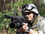 Soldier in ACU aiming his Colt M4 with M203 grenade launcer