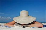 One of a long series of photos taken on the Mexican Caribbean coast. Woman reading on the beach with a big hat