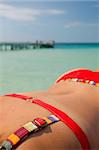 One of a large series. Woman in red bikini sunbathing on a tropical jetty