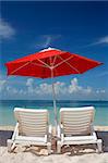 Sun loungers and parasol on an empty tropical beach