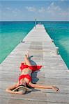 One of a large series. Woman in red bikini sunbathing on a tropical jetty
