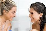 one blond girl and one brunette in the same bathtub with foam