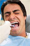 dentist holding a syringe and anesthetizing his patient