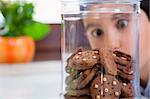 little boy looking at cookies in a jar