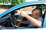 Drunk man sitting in drivers and holding a bottle alcohol