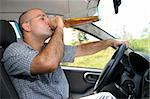Drunk man sitting in drivers sit and drinking from a bottle