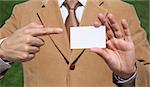A business man showing a blank card with his finger