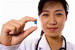 Female doctor handing pill in white background.