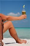 Woman sitting in a deckchair drinking beer