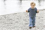 baby boy on empty pebble beach