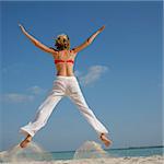 Woman jumping on a beach in square formatt