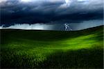 Beautiful green meadow with storm clouds and thunders