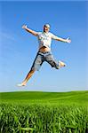 Man making a big jump on a beautiful green meadow