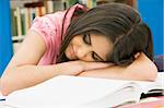 Tired female student sleeping at desk