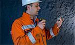 Engineer inspecting mineral with flashlight stock photo