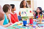 Elementary school pupil discussing picture with classmates