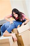 Young playful couple unpacking boxes at new home