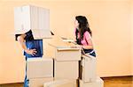 Young couple being silly with moving boxes at home