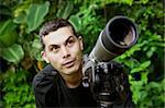 Handsome nature guide with a telescope in the rainforest