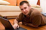 happy man on sofa with laptop