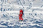 Woman in red and ski traces on snow