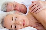 Couple lying in bed together sleeping