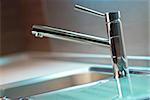 Modern stainless steel tap in white kitchen