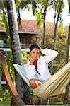 20-25 years woman portrait ralaxing on hammock at exotic surrounding
