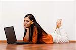 casual woman lying on flor with laptop