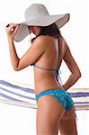 Sexy girl wearing bikini with summer hat and hammock on the background