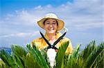 Portrait of senior Italian woman gardening with hedge clippers, looking at camera