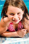 Young child enjoying the sun in and around the swimming pool