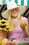 A beautiful young woman shopping for fruit in a market