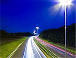 high way by night with traffic passing by with only the lights visible