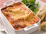 Close up of Dish of Lasgane with Salad Leaves and Italian Bread